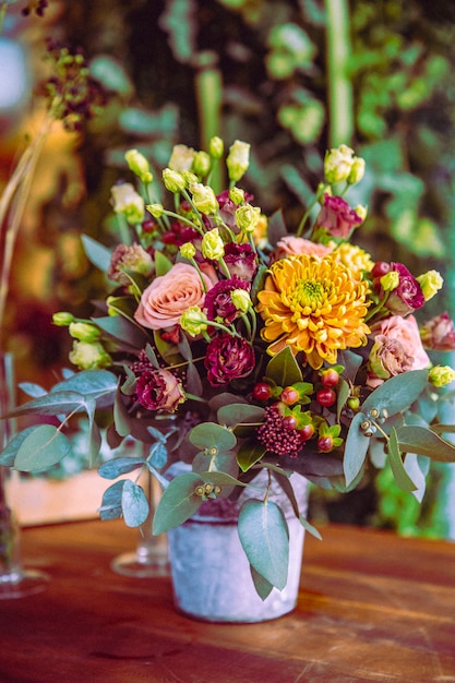 Бесплатное фото Цветочная композиция в ведре розы хризантема вид сбоку