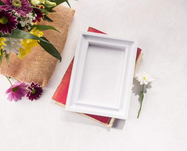 Flower composition and photo frame on grey desk