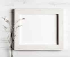 Free photo flower and a frame on wooden wall