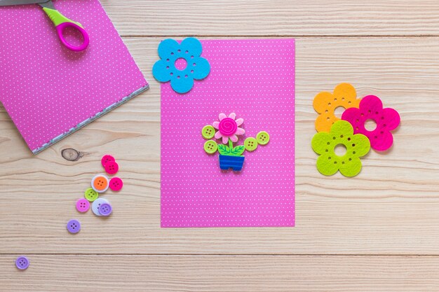 Flower pot decorated on pink card over the wooden table