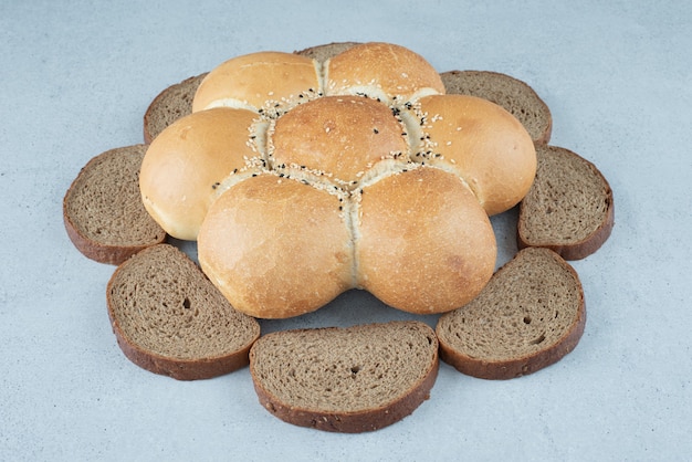 Foto gratuita fette di pane e segale a forma di fiore sulla superficie della pietra
