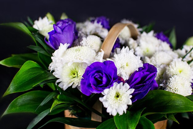Flowers in a basket. roses in a basket. present. flowers are white and purple.