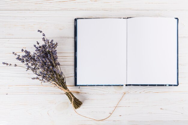 Flowers bouquet with blank notebook on light table