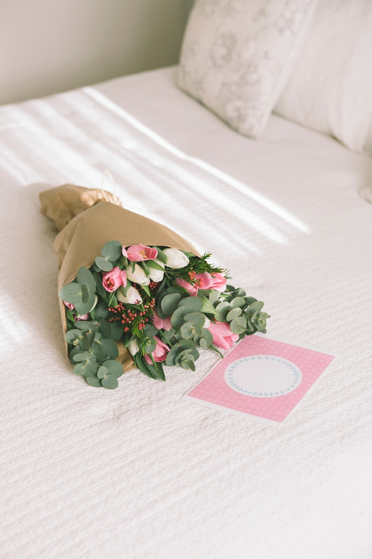 Free Photo flowers bouquet in wrapping paper on bed