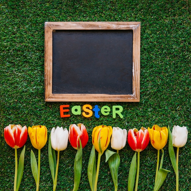 Flowers and chalkboard with word Easter