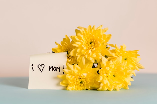 Foto gratuita fiori e carta di congratulazioni amo mamma