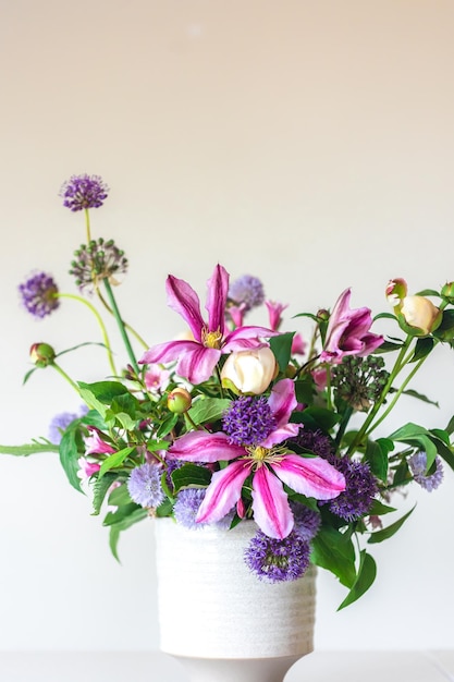 Fiori da un giardino domestico in un vaso su sfondo bianco