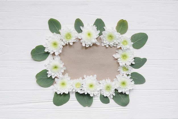 Flowers and leaves around paper sheet