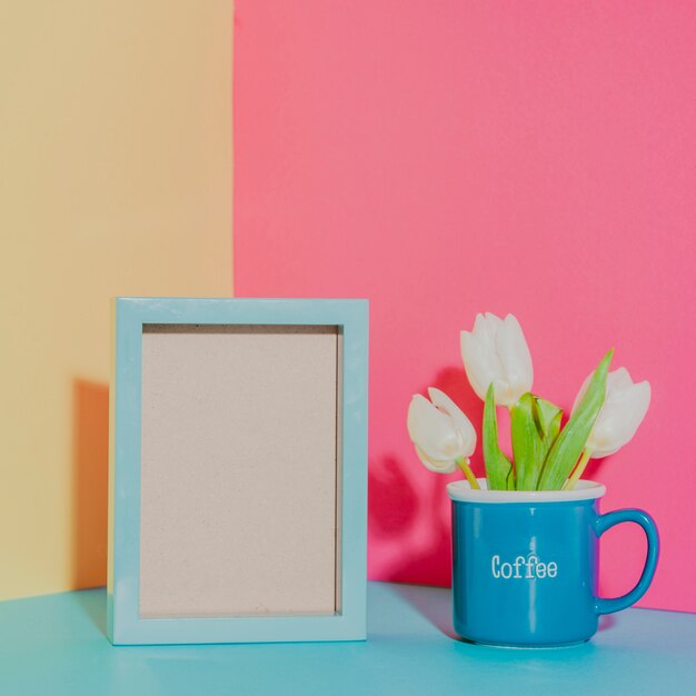 Flowers in mug near frame