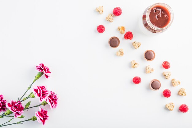 Flowers near sauces and berries