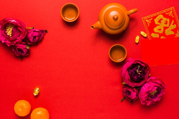 Flowers near tea set and tangerines