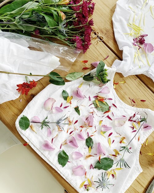 Flowers petals and leaves on a rug on wooden surface