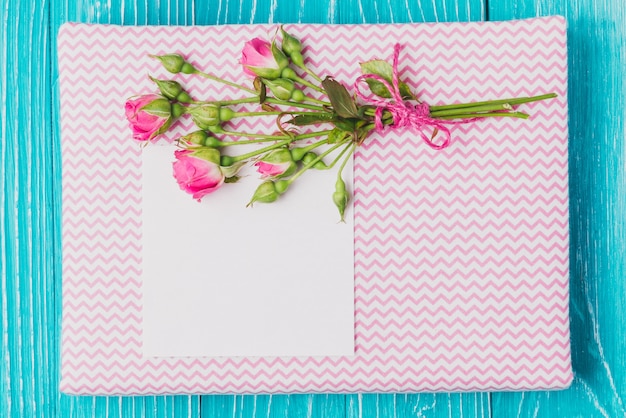 Flowers and piece of paper over book