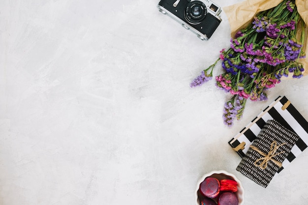 Flowers and retro camera near gifts and macaroons