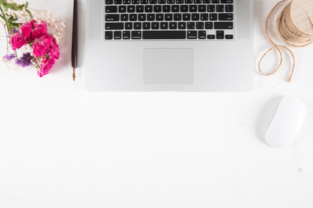 Free photo flowers and rope near laptop and pen