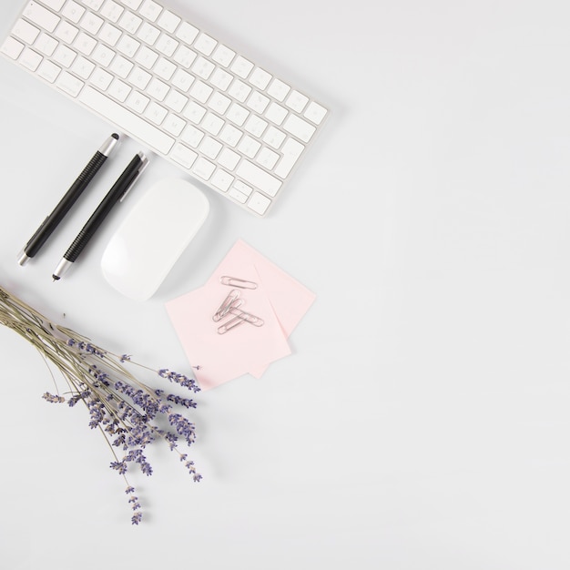 Flowers and stationery near keyboard and mouse