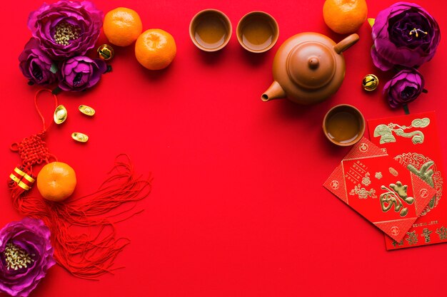 Цветы и мандарины рядом с принадлежностями для чайной церемонии