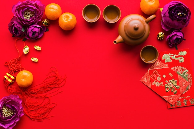 Цветы и мандарины рядом с принадлежностями для чайной церемонии