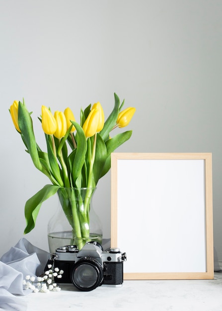 Flowers in vase with frame beside
