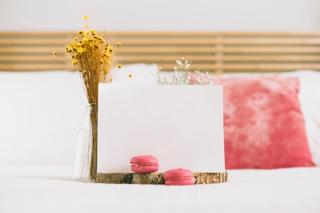 Flowers in vase with macaroons and blank paper