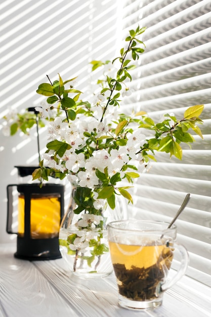 Fiori in un vaso con una tazza di tè