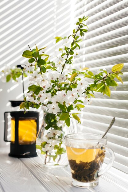 Flowers in a vase with a tea cup