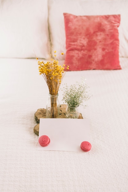 Flowers in vases with macaroons and paper