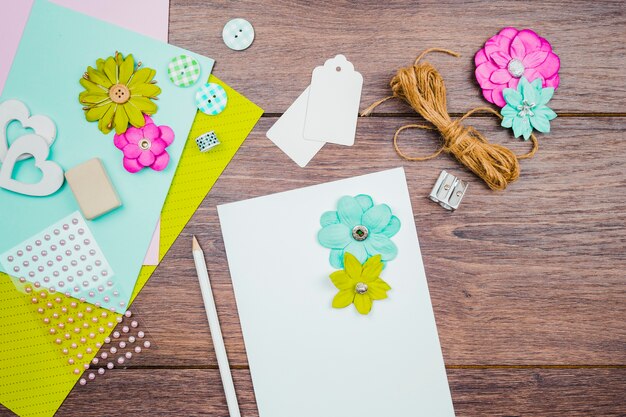 Цветы на белой бумаге с карандашом; теги; цветок и веревка на деревянный стол