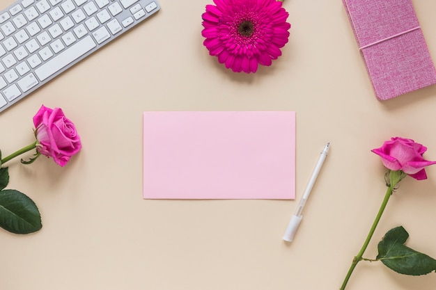 Flowers with blank paper and keyboard 