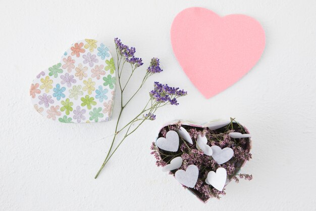 Flowers with paper hearts in box 