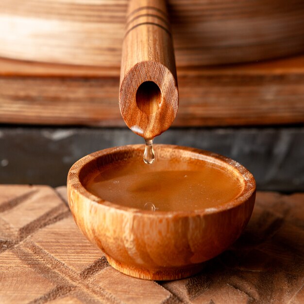 Flowing oil into wooden bowl