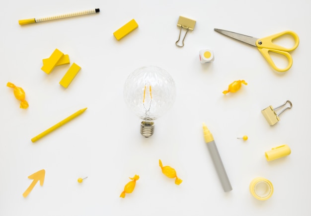 Fluorescent bulb surrounded by various stationeries and candies