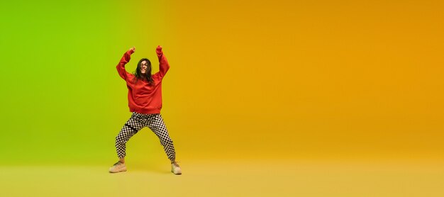 チラシ。ネオンの光のダンスホールでカラフルなスタイリッシュな服を着てヒップホップを踊るスタイリッシュなスポーティーな女の子。