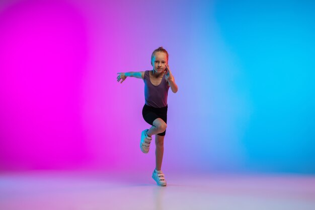 Flyer. Teenage girl, professional runner, jogger in action, motion isolated on gradient pink-blue