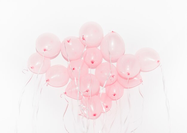 Flying pink balloons for birthday party against white backdrop