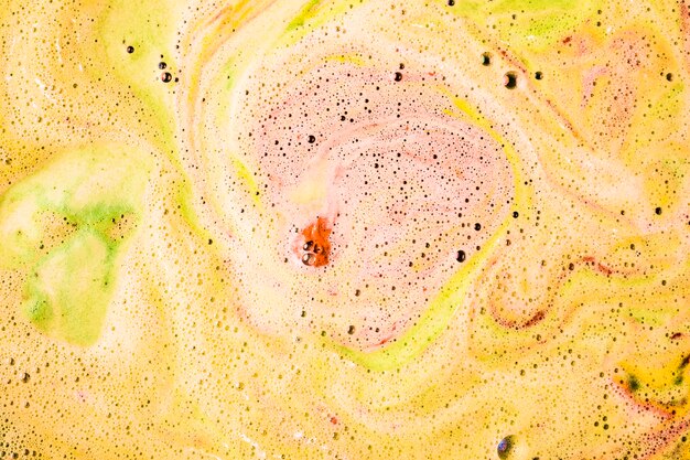 Foam and bubbles form on the surface of bath bomb dissolve in water