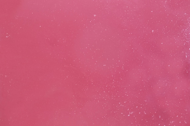 Foam flakes on pink water