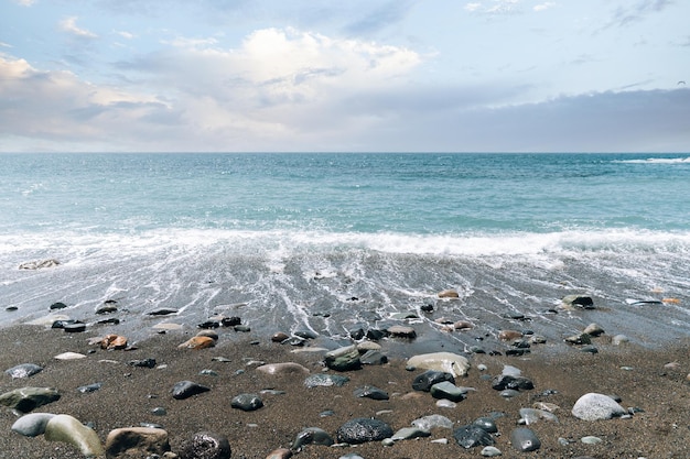 Foto gratuita onde schiumose del mare che lavano la riva sabbiosa