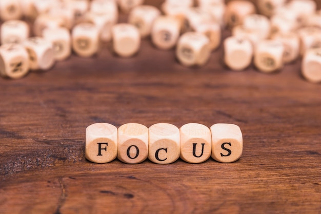 Focus letters written on wooden cubes over table
