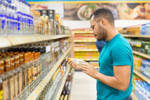 Focused African American man holding alcohol drink