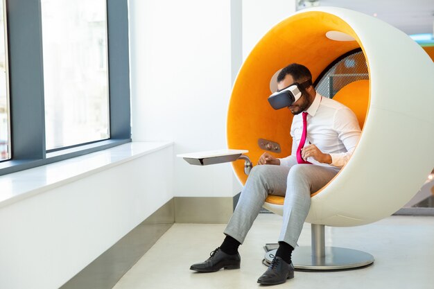 Focused African American user wearing VR glasses