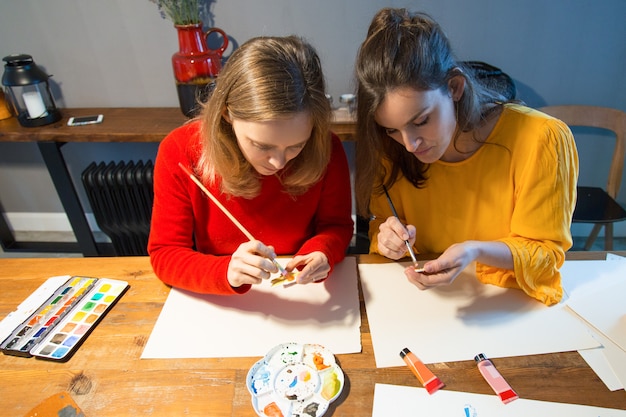 Focused art school students learning painting