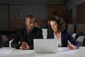 Free photo focused business partners looking at laptop in office