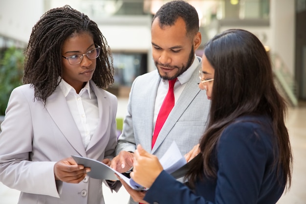 Focused business team reading agreement together