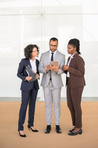 Focused business team standing in office hallway