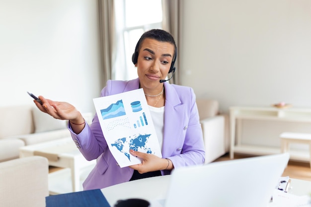 Focused business woman presenting charts and graphs on video call online Young business woman having conference call with client on laptop Young woman explaining how business work