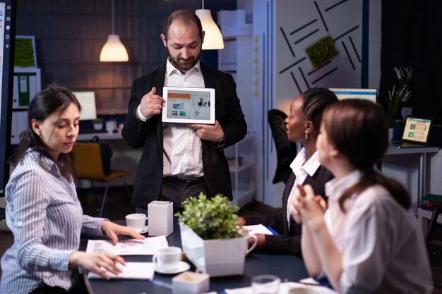 Focused businessman showing corporate graphs presentation using tablet working at company ideas