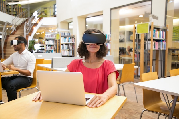 Foto gratuita donna caucasica messa a fuoco che indossa la cuffia avricolare di vr