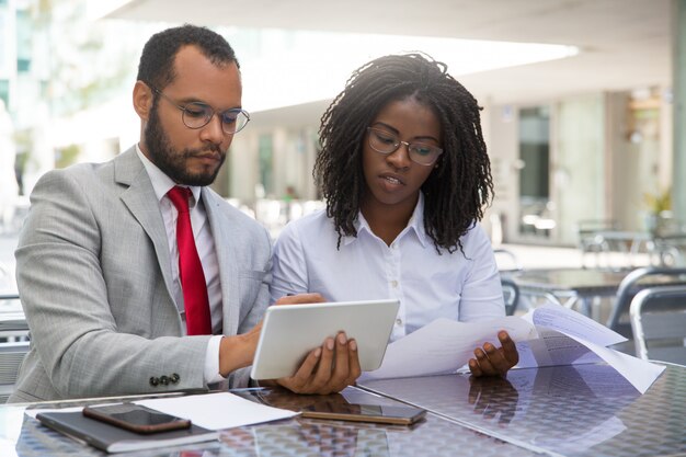 Focused coworkers checking reports