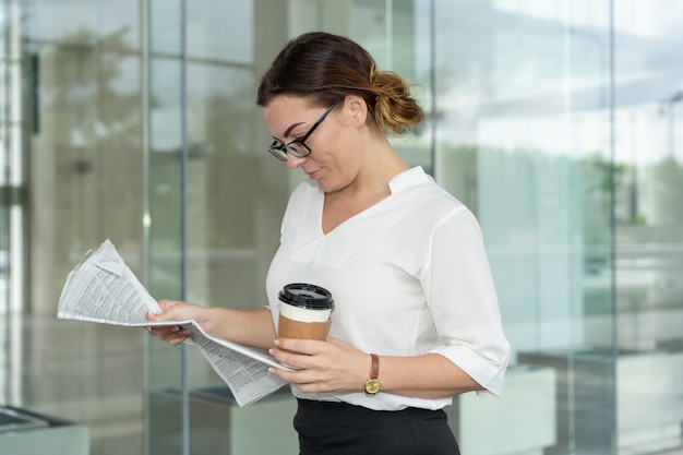 Focused female expert looking through latest financial news